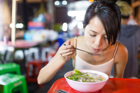 Woman eating in night market of bangkok cityの写真素材