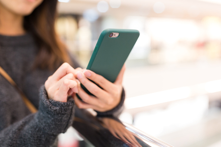 Woman sending sms on cellphoneの写真素材