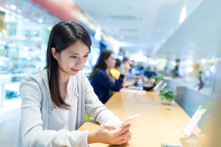 Woman use of mobile phone in share officeの写真素材