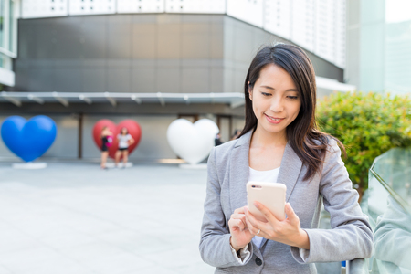 Businesswoman working on cellphone at outdoorの写真素材