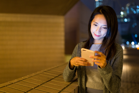 Woman use of mobile phone at nightの写真素材