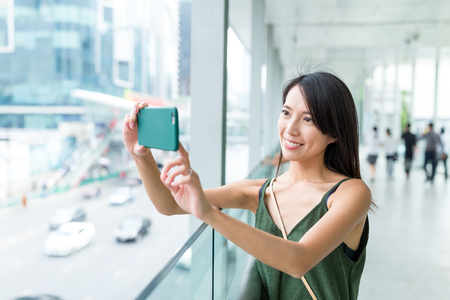 Woman taking photo in the cityの写真素材