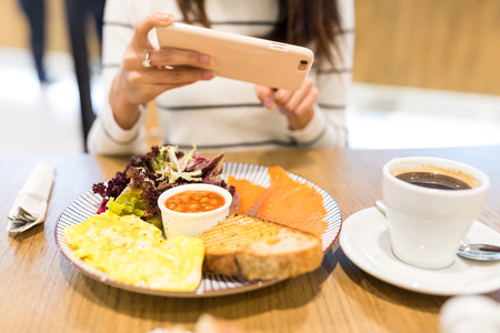 Woman taking photo on her mealの写真素材