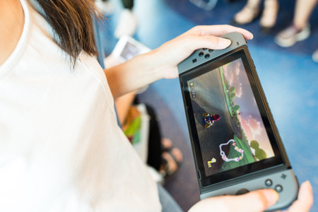 Hong Kong, 19 May 2017 -:Woman holding a Nintendo Switch video game systemのeditorial素材