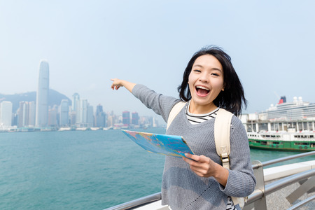 Woman pointing far away with paper mapの写真素材