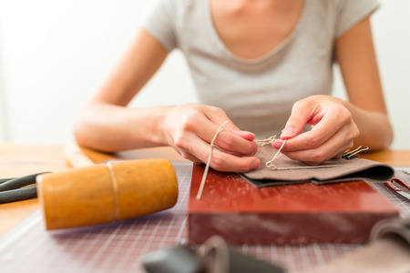 Woman making bag with leatherの写真素材