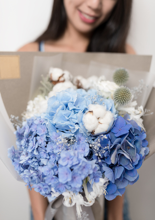 Woman holding a bouquet of flowerの写真素材