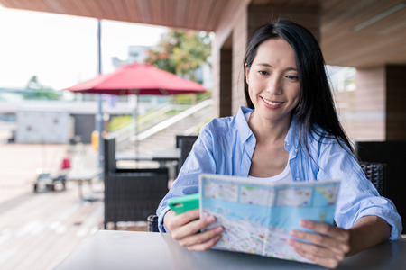 Woman use of city map and cellphone in Hong Kong