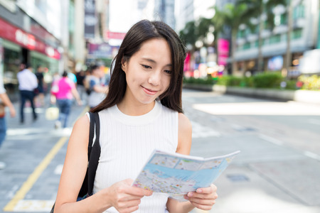Young Woman looking for direction on mapの写真素材