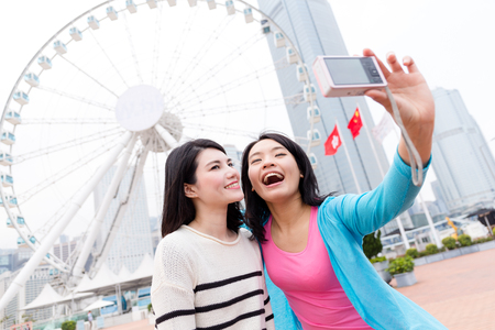 Woman using digital camera to take photoの写真素材