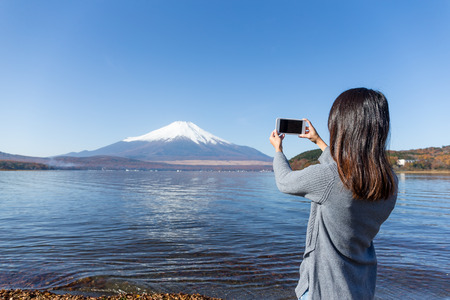 Woman taking photo on Fujisanの写真素材