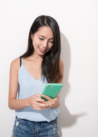 Woman using mobile phone over white backgroundの写真素材