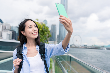Woman taking selfie by mobile phone in Hong Kongの写真素材