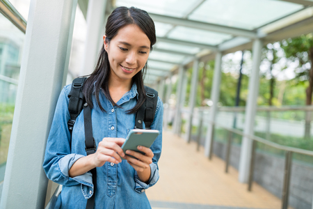 Woman using mobile phone in cityの写真素材