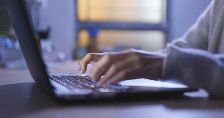 Woman working on laptop computer at night の写真素材