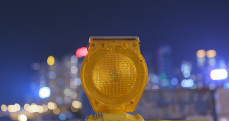 Caution yellow light in the city at night の写真素材