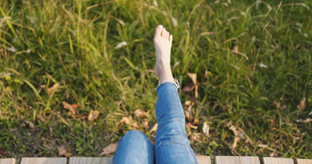 Woman sitting on wooden path from top viewの写真素材