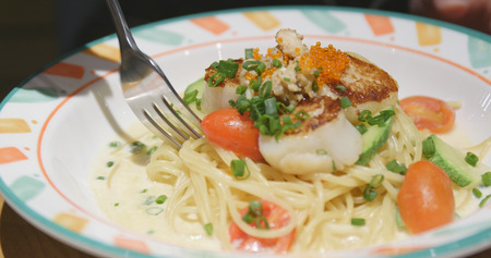 Eating Spaghetti in restaurant の写真素材