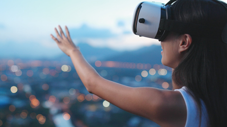 Woman watching with virtual reality device in the sunset の写真素材