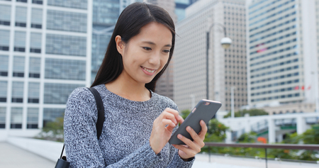 Woman look at mobile phone cityの写真素材