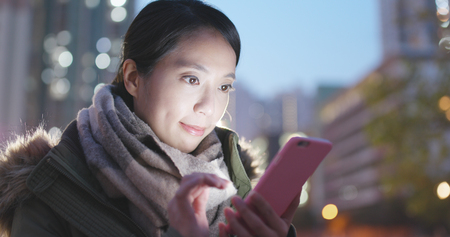 Woman use of mobile phone at night の写真素材