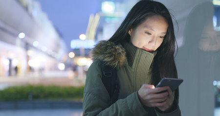 Woman use of smart phone in the winter time の写真素材