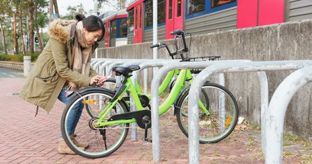 Woman using share bike in the city の写真素材