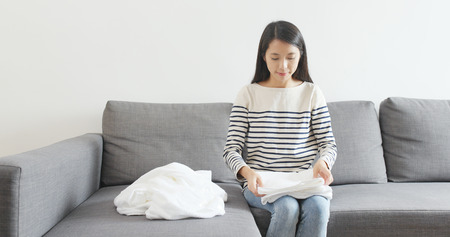 Housewife folding white towel, woman doing housework at home の写真素材