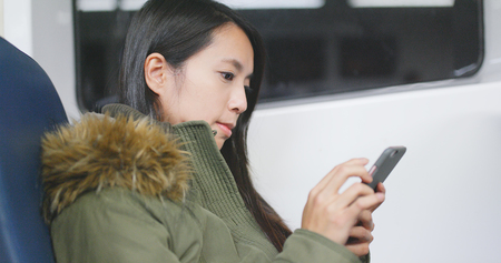 Woman use of mobile phone on ferry の写真素材