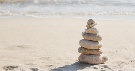 Balancing stone tower against morning sea の写真素材