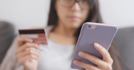 Woman shopping online with cellphone and credit card の写真素材
