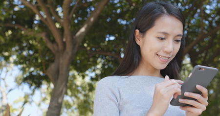 Woman sending sms on cellphone の写真素材