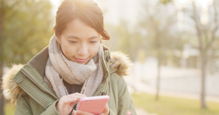 Woman use of mobile phone under sunset time の写真素材