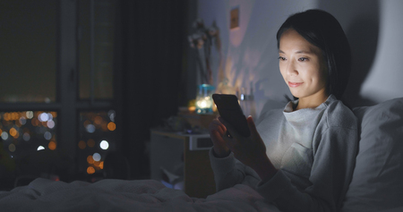 Woman use of smart phone at night の写真素材