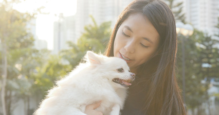 Woman hugging Pomeranian dog の写真素材