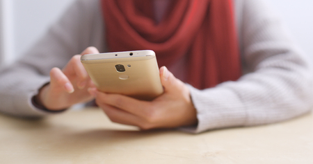 Woman using mobile phone at home の写真素材
