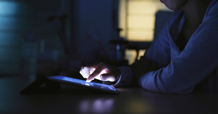 Using digital tablet computer at night の写真素材