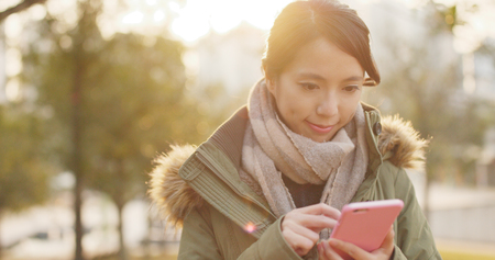 Woman use of mobile phone under sunset time の写真素材
