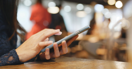 Woman use of smart phone in coffee shopの写真素材