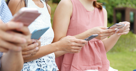 People using cellphone in the park の写真素材