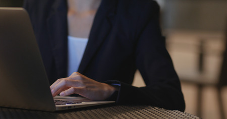 Businesswoman use of laptop computer at nightの写真素材