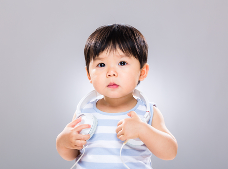 Little boy with music headphone on shoulderの写真素材