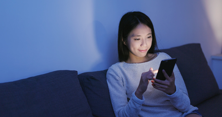Woman use of mobile phone at night の写真素材