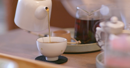 Pouring tea to a cup in restaurantの写真素材