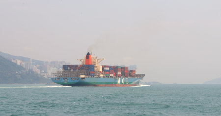 Victoria Harbor, Hong Kong, 19 April 2018:- Cargo ship crossing the bay