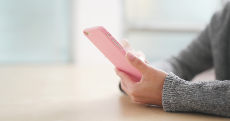 Woman use of mobile phone at homeの写真素材