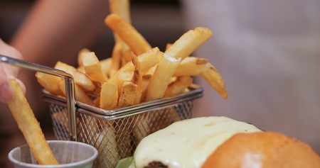 Eating french fries and burgerの写真素材