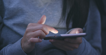 Woman use of mobile phone at nightの写真素材