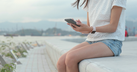 Close up of woman using mobile phone in cityの写真素材