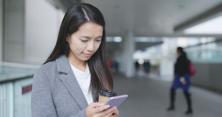 Businesswoman using smart phone at outdoorの写真素材